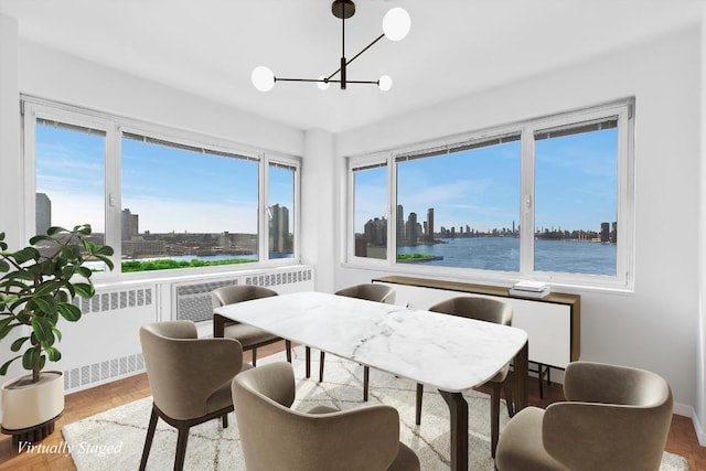 dining space featuring a water view, parquet floors, radiator, and an inviting chandelier