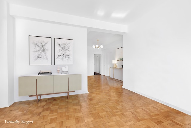 hallway with baseboards and a notable chandelier