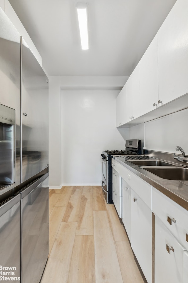 1 Fordham Hill Oval Unit 1E, New York City, NY 10468 - kitchen featuring appliances with stainless steel finishes, light wood-type flooring, and white cabinets