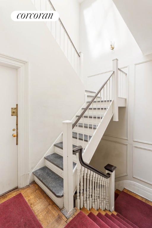 stairway featuring parquet flooring