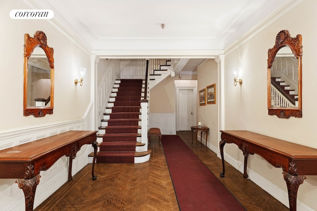 hallway with ornamental molding, dark parquet flooring, and decorative columns