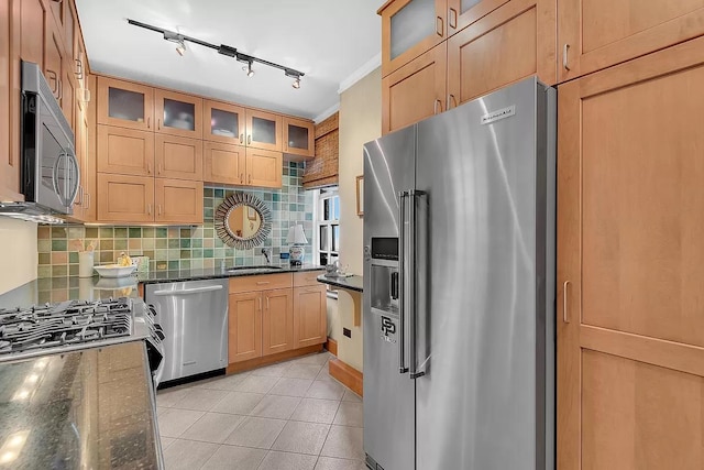 kitchen featuring light tile patterned floors, glass insert cabinets, stainless steel appliances, and dark stone counters