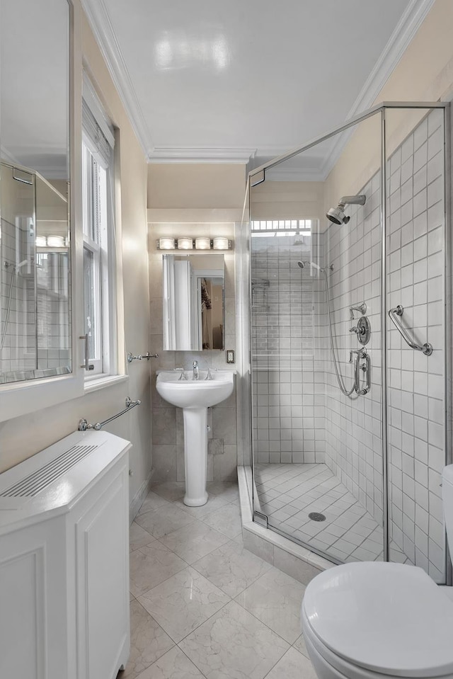 bathroom featuring a stall shower, marble finish floor, crown molding, and toilet