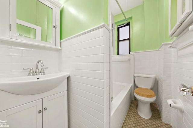 bathroom featuring tile patterned flooring, a bathtub, tile walls, and toilet