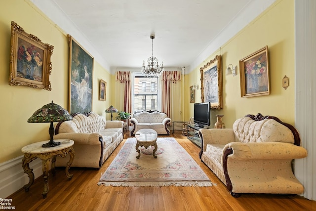 living room featuring crown molding, a notable chandelier, and hardwood / wood-style flooring