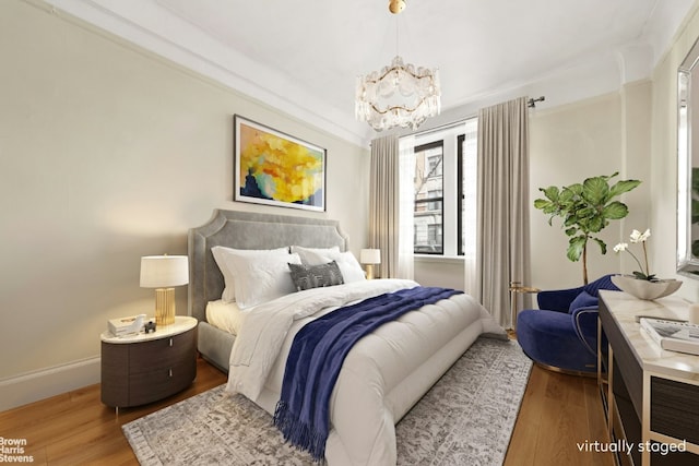 bedroom featuring hardwood / wood-style flooring and a chandelier