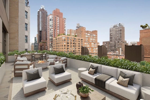 view of patio with an outdoor living space with a fire pit and a view of skyline
