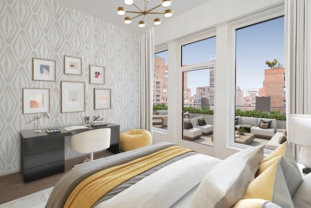 bedroom featuring wallpapered walls, a view of city, access to exterior, a chandelier, and wood finished floors