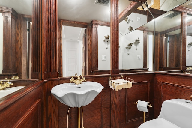 half bath featuring toilet, a sink, and visible vents