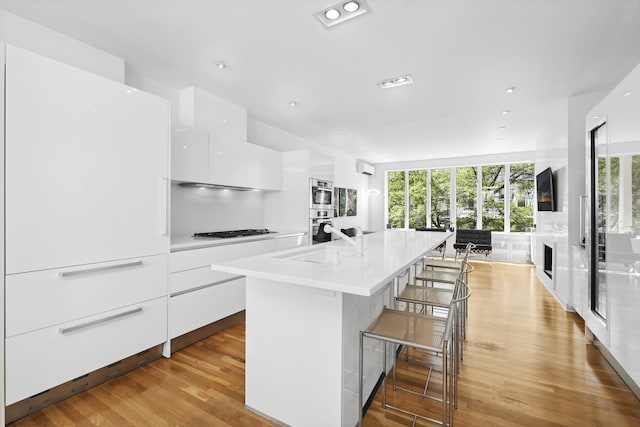 kitchen with a healthy amount of sunlight, modern cabinets, white cabinetry, and gas cooktop