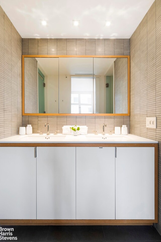 bathroom with vanity, tile walls, and decorative backsplash