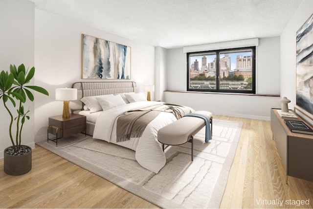 bedroom with light hardwood / wood-style flooring and a textured ceiling