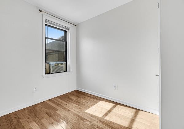 spare room with cooling unit and light hardwood / wood-style floors