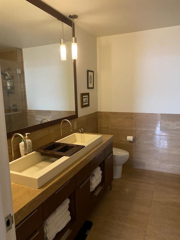 bathroom with tile walls, toilet, wainscoting, vanity, and tile patterned floors