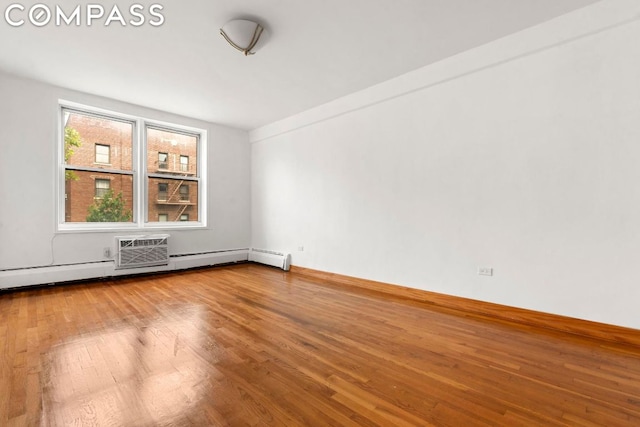 unfurnished room featuring a baseboard radiator and hardwood / wood-style floors