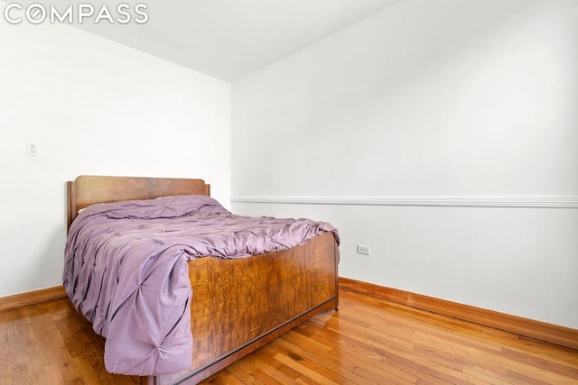 bedroom featuring vaulted ceiling and hardwood / wood-style flooring