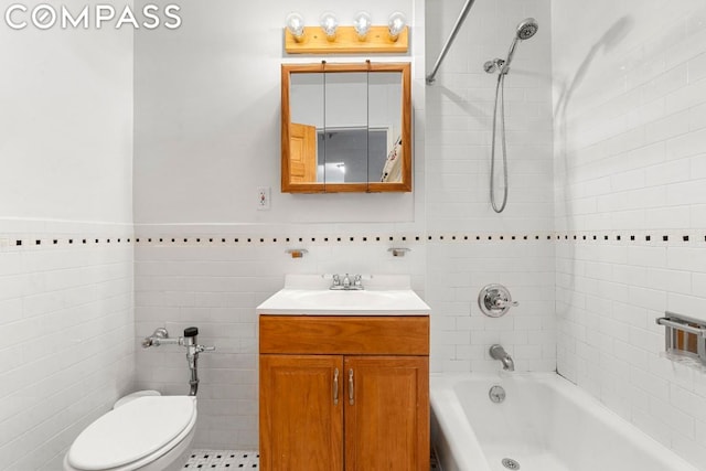 full bathroom with toilet, tiled shower / bath combo, tile walls, and vanity