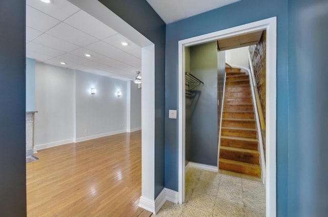 corridor featuring light hardwood / wood-style flooring and a drop ceiling