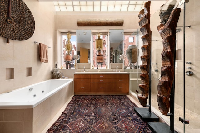 178 E 75th St, New York City, NY 10021 - bathroom featuring double vanity, a jetted tub, a tile shower, tile patterned flooring, and tile walls