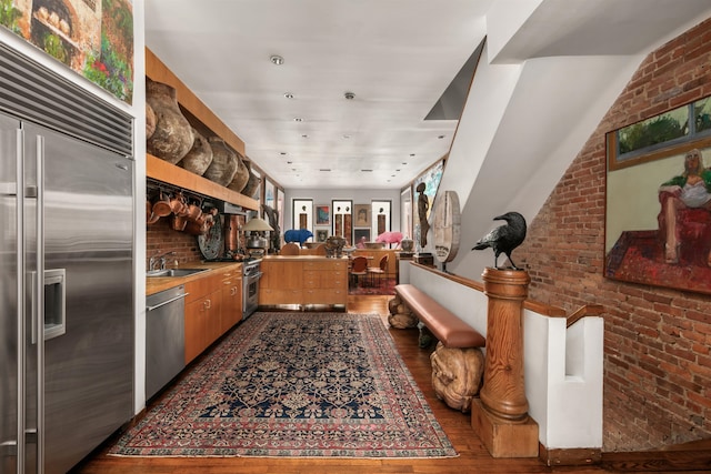 178 E 75th St, New York City, NY 10021 - kitchen with high quality appliances, a sink, wood finished floors, a peninsula, and open floor plan