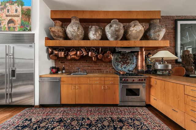 178 E 75th St, New York City, NY 10021 - kitchen with high quality appliances, a sink, dark wood-style floors, and light countertops