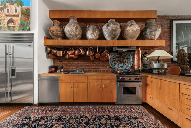 178 E 75th St, New York City, NY 10021 - kitchen with high quality appliances, a sink, dark wood-type flooring, and light countertops