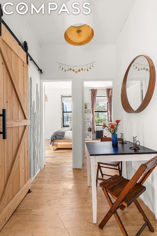 hall with a barn door and light wood-type flooring