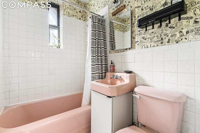 full bathroom featuring toilet, vanity, tile walls, tasteful backsplash, and shower / tub combo with curtain