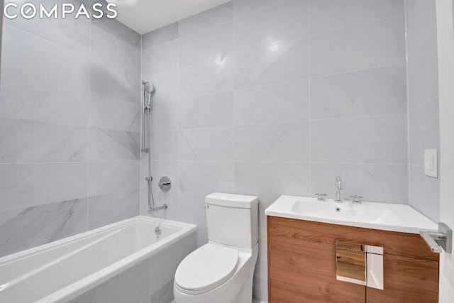 full bathroom featuring tile walls, vanity, tiled shower / bath, and toilet