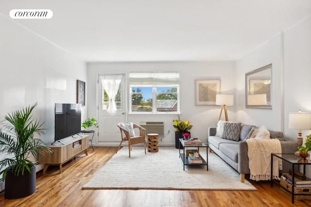 living area with visible vents, wood finished floors, and a wall mounted AC