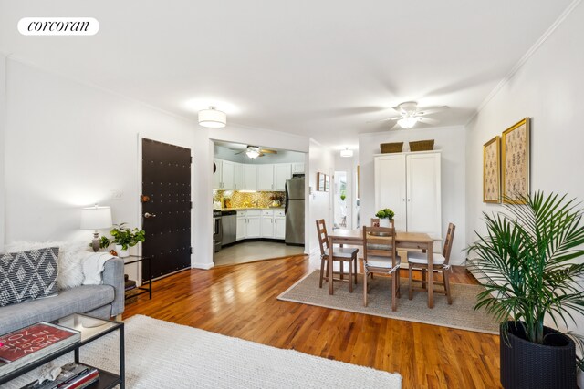 dining space with crown molding, hardwood / wood-style flooring, and ceiling fan