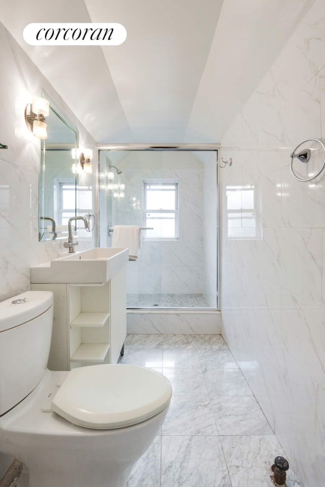 full bathroom with tile walls, a marble finish shower, lofted ceiling, toilet, and vanity