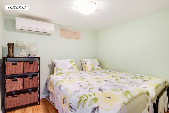 bedroom featuring visible vents, an AC wall unit, and wood finished floors