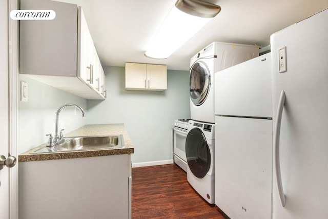 clothes washing area featuring stacked washer and dryer, laundry area, baseboards, dark wood-style flooring, and a sink