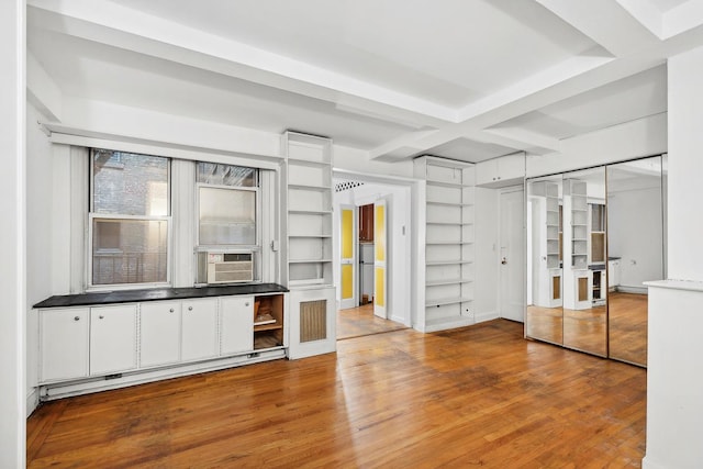 interior space with a baseboard heating unit, coffered ceiling, cooling unit, and wood finished floors