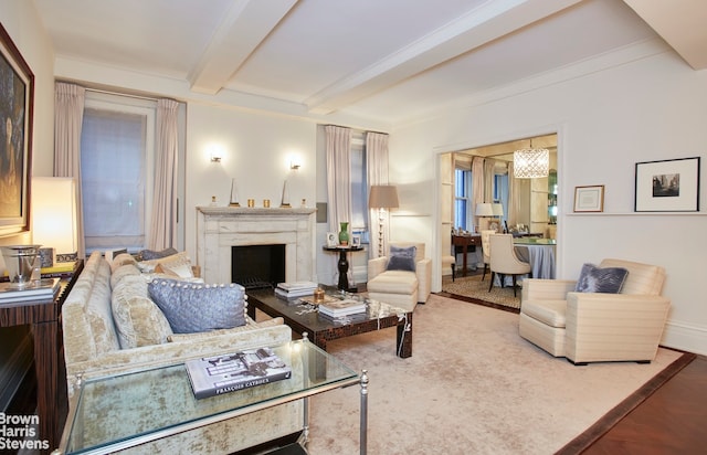 living area with beamed ceiling, an inviting chandelier, a fireplace, and baseboards