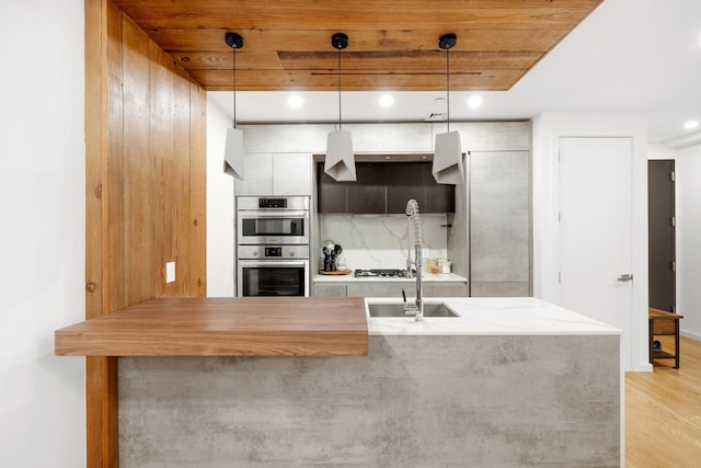 kitchen featuring tasteful backsplash, pendant lighting, wooden ceiling, and double oven