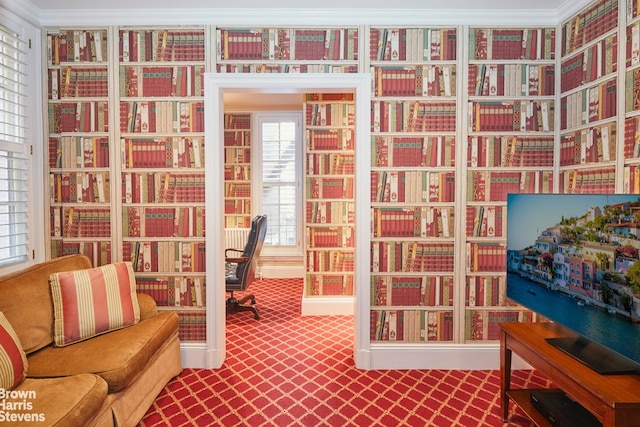 office area with carpet flooring, crown molding, and wall of books