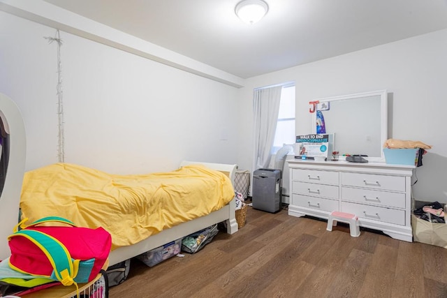 bedroom featuring baseboard heating and dark hardwood / wood-style floors