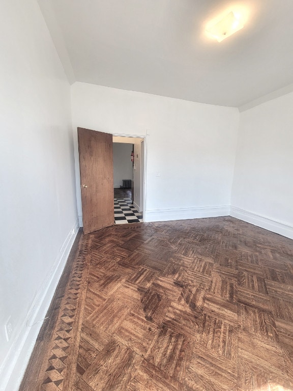 unfurnished room with dark parquet flooring