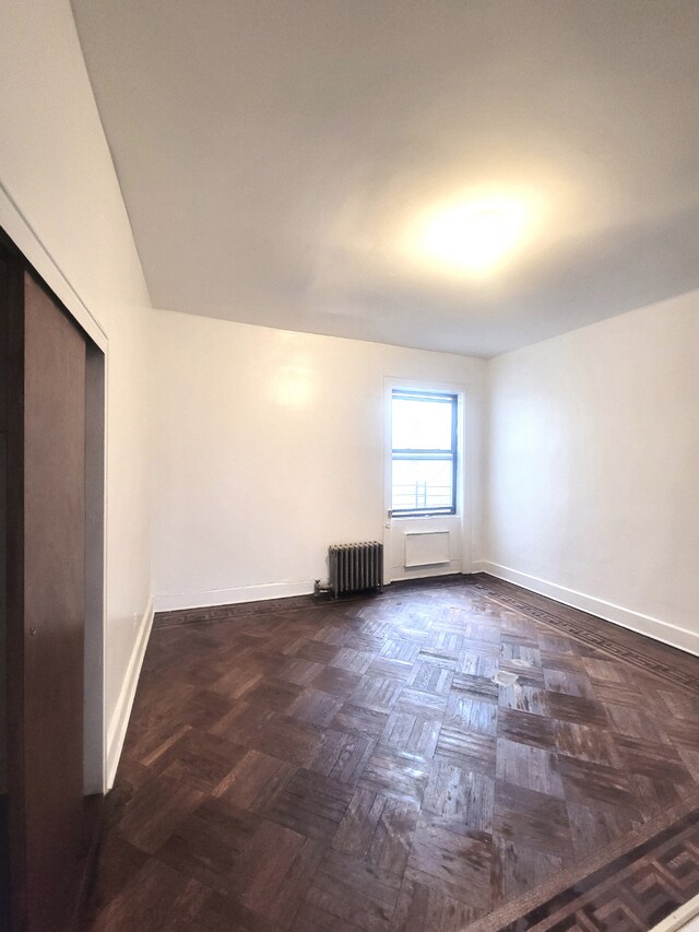 interior space featuring radiator and dark parquet floors