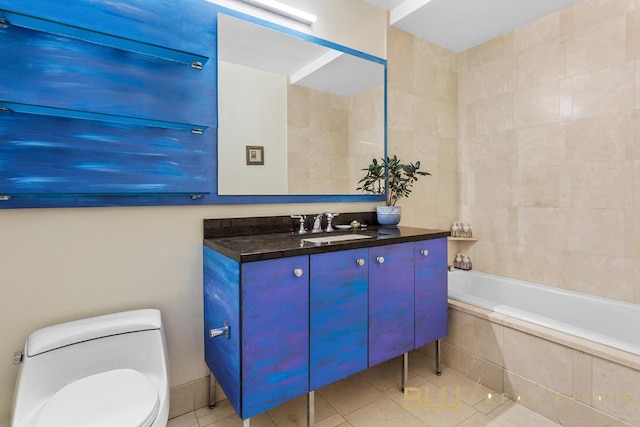 bathroom featuring tiled bath, tile patterned floors, toilet, and vanity