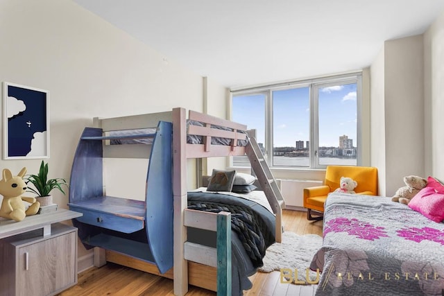 bedroom featuring a water view and light wood-type flooring