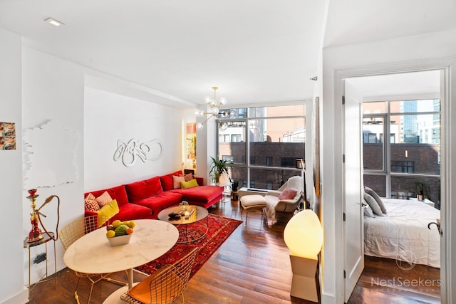 living room featuring wood-type flooring, a chandelier, and a wealth of natural light