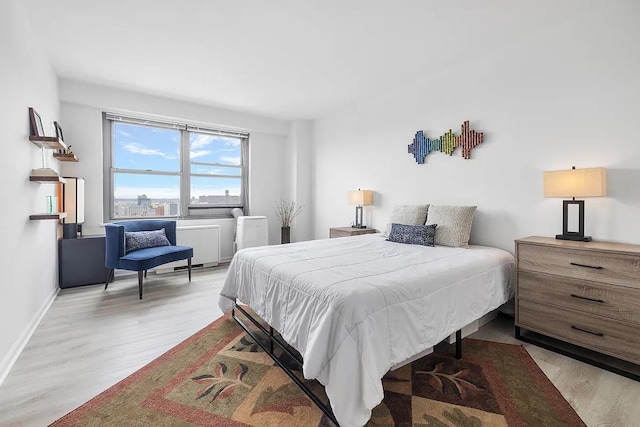 bedroom with light wood-type flooring and baseboards