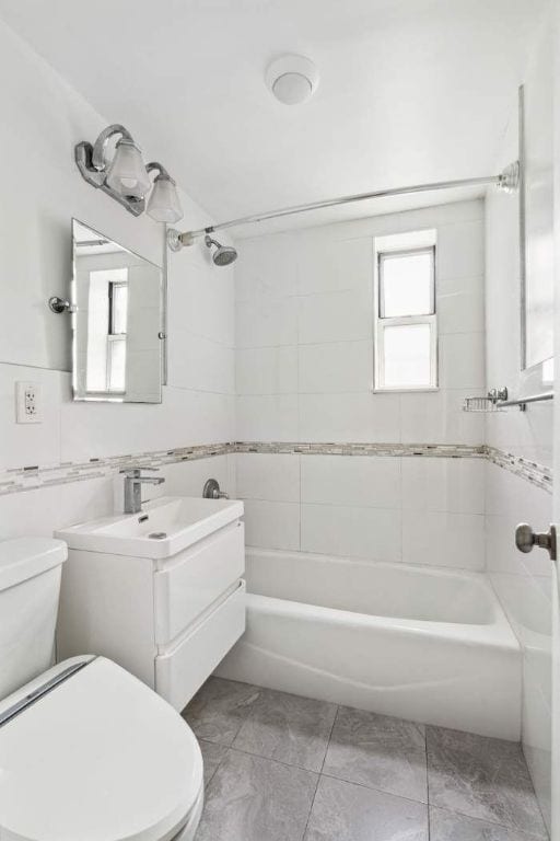 full bathroom with vanity, toilet, and tiled shower / bath combo