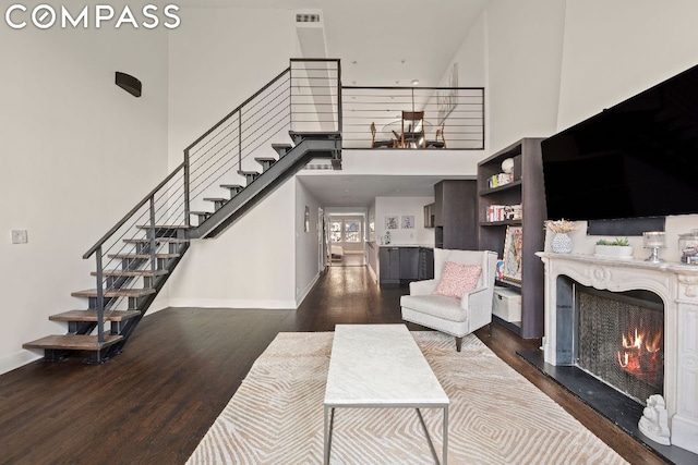 living room with a high ceiling and dark hardwood / wood-style floors