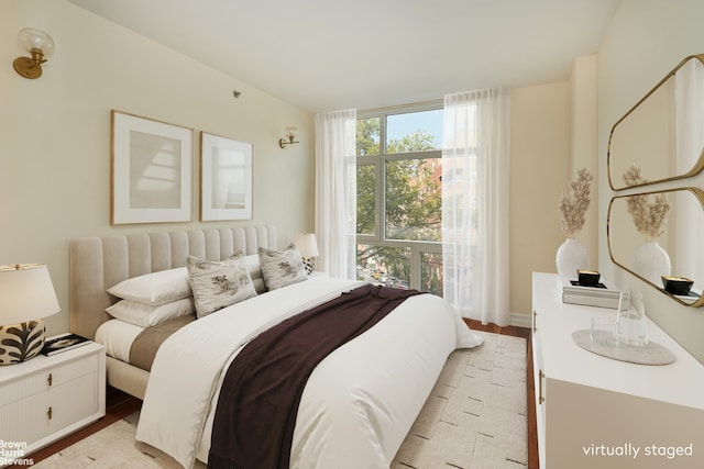 bedroom with multiple windows and light wood-style flooring