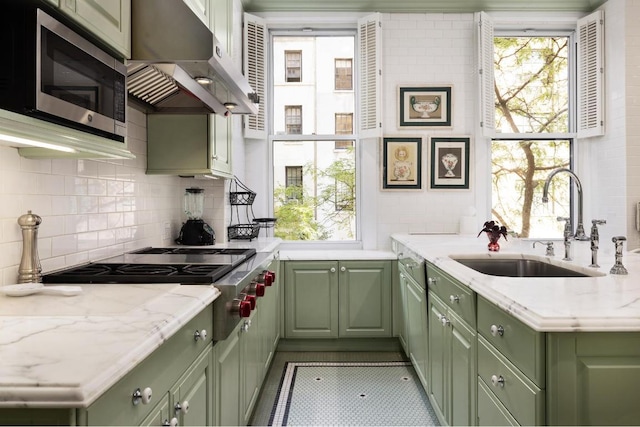 kitchen with a wealth of natural light, appliances with stainless steel finishes, and green cabinetry