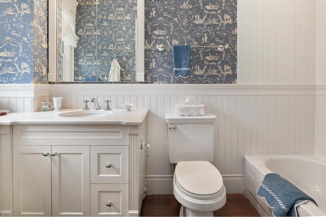 bathroom featuring a tub, toilet, and vanity